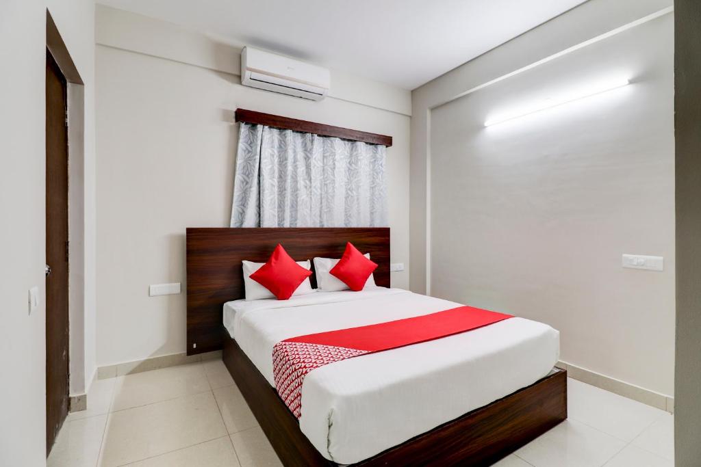 a bedroom with a bed with red pillows at Aster Suites in Bangalore
