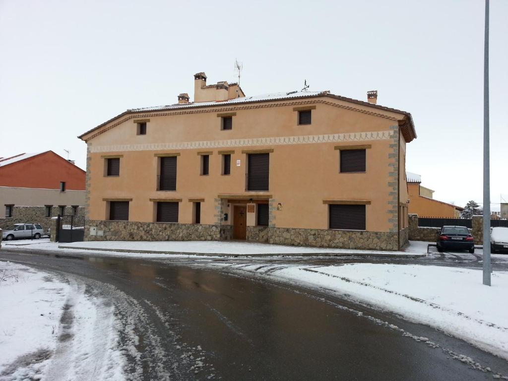 un edificio en una calle con nieve en el suelo en Hotel Rural La Casa del Tio Telesforo, en Trescasas