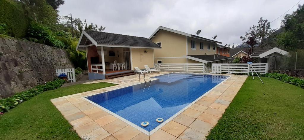 uma piscina em frente a uma casa em Aconchego em Teresópolis com piscina privativa próximo a feirinha em Teresópolis