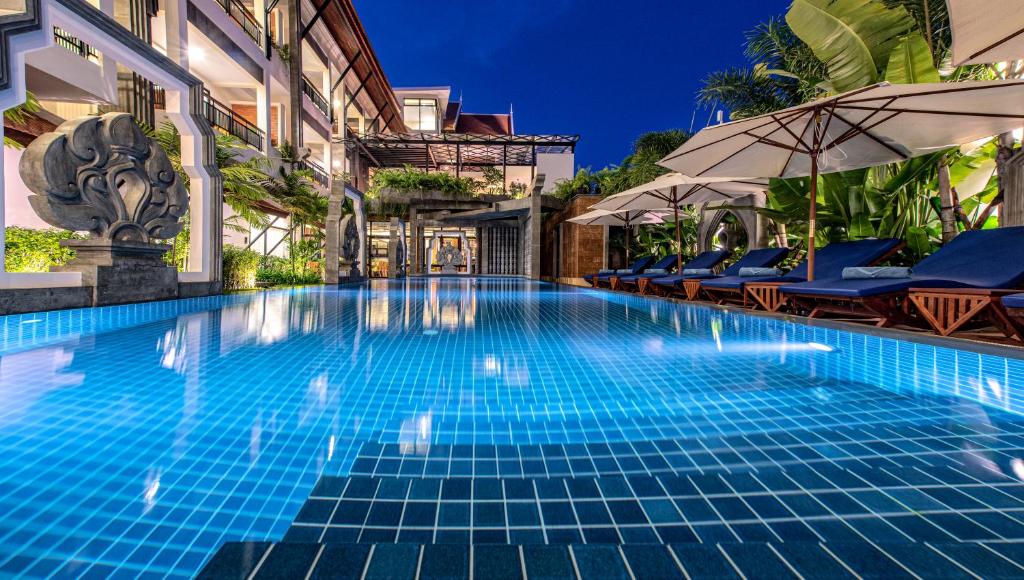 a swimming pool at a resort with chairs and umbrellas at Araya Angkor Residence in Siem Reap