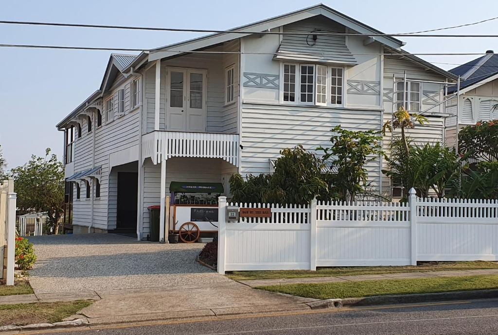 a white house with a white fence in front of it at Sustainable B&B by the Bay in Brisbane