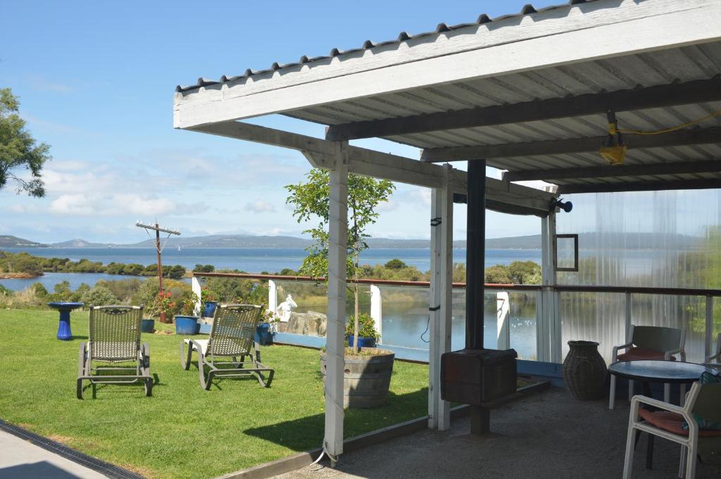 eine Pergola mit Stühlen und einem Tisch auf dem Rasen in der Unterkunft Kinsellas Water Views in Albany