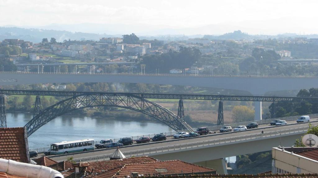 a bridge over a river with cars on it at Residencial Porto Novo - Alojamento Local in Porto