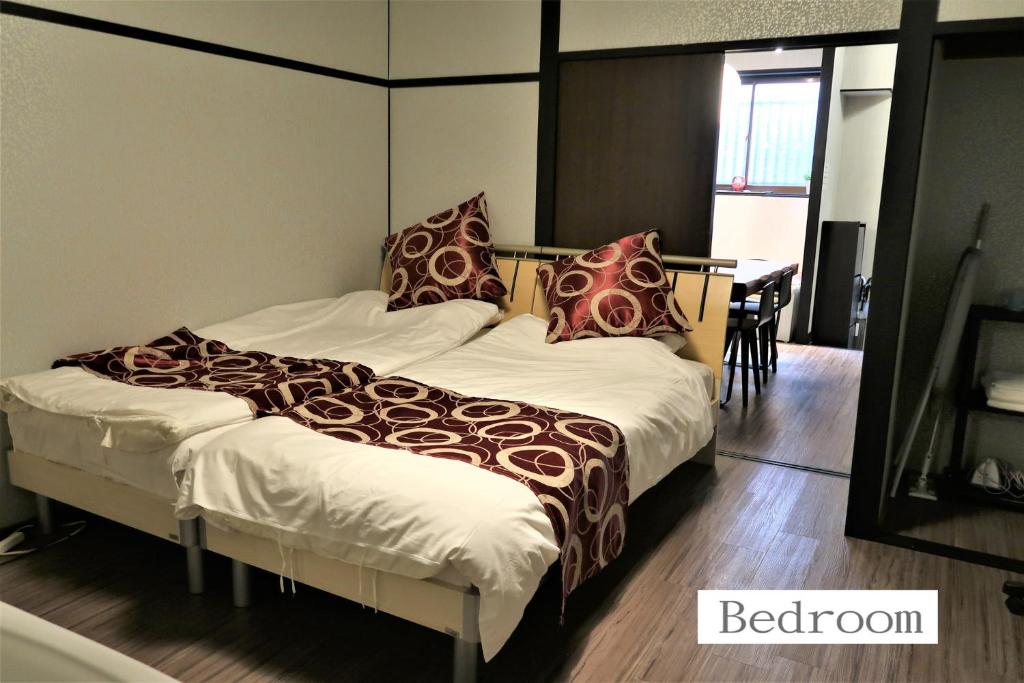 - une chambre avec 2 lits et une table dans l'établissement 中川西 地下鉄今里駅一戸建 Samurai House Guest House Imazato 難波直通 最大7名, à Osaka