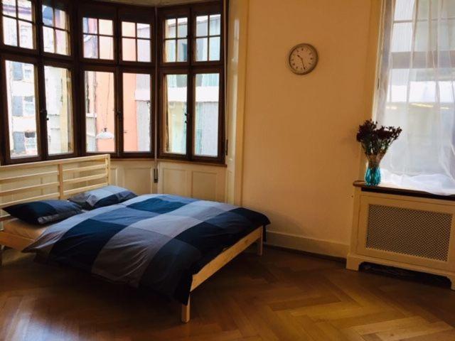 ein Schlafzimmer mit einem Bett und einer Uhr an der Wand in der Unterkunft Apartment Marktplatz in Basel