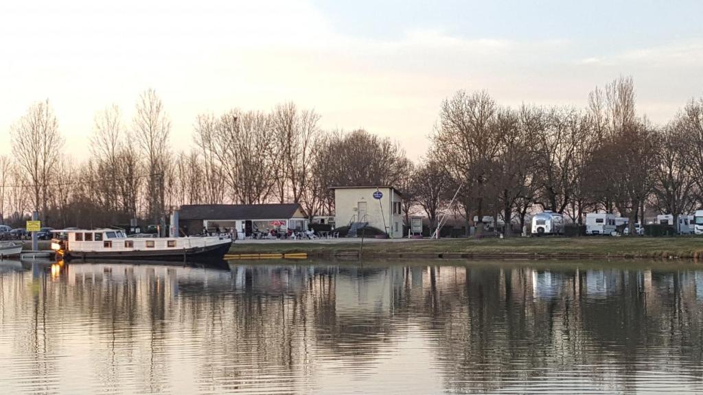 a boat is docked at a marina on a lake at CAMPING LES HERLEQUINS in Losne