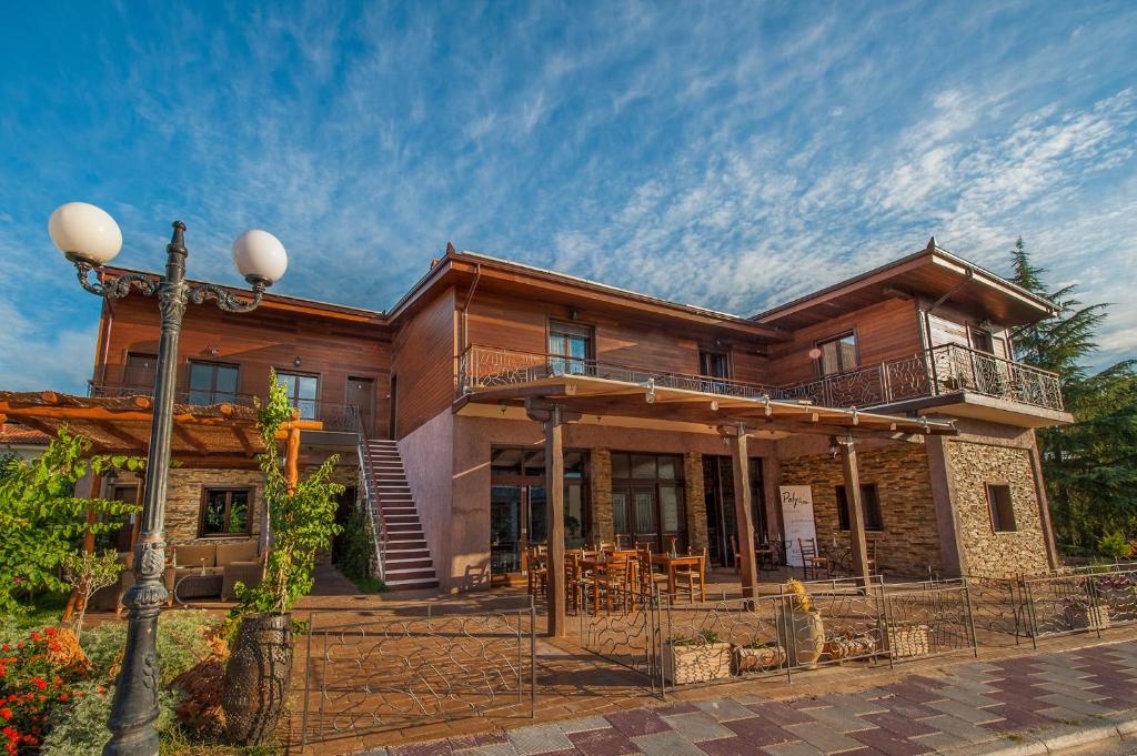 a large wooden house with a balcony at Polys Guest House in Katachás