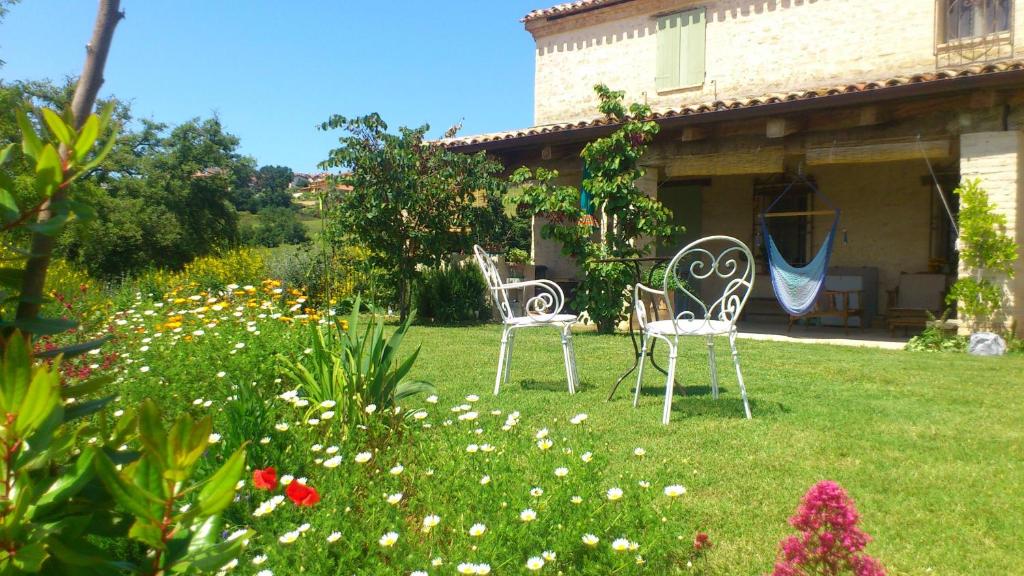 two chairs sitting in the yard of a house at Poggio Dei Prugnoli in Tavoleto