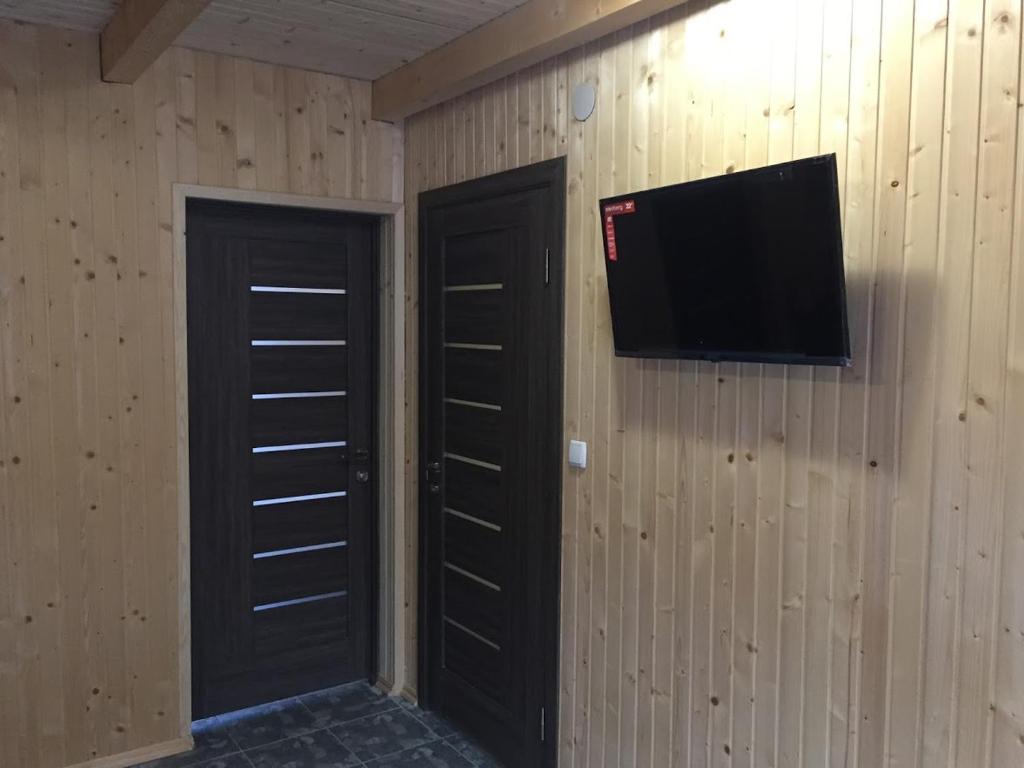 バコヴェルにあるКотеджний комплекс "Вершина"の黒いドア2つと壁にテレビが備わる客室です。