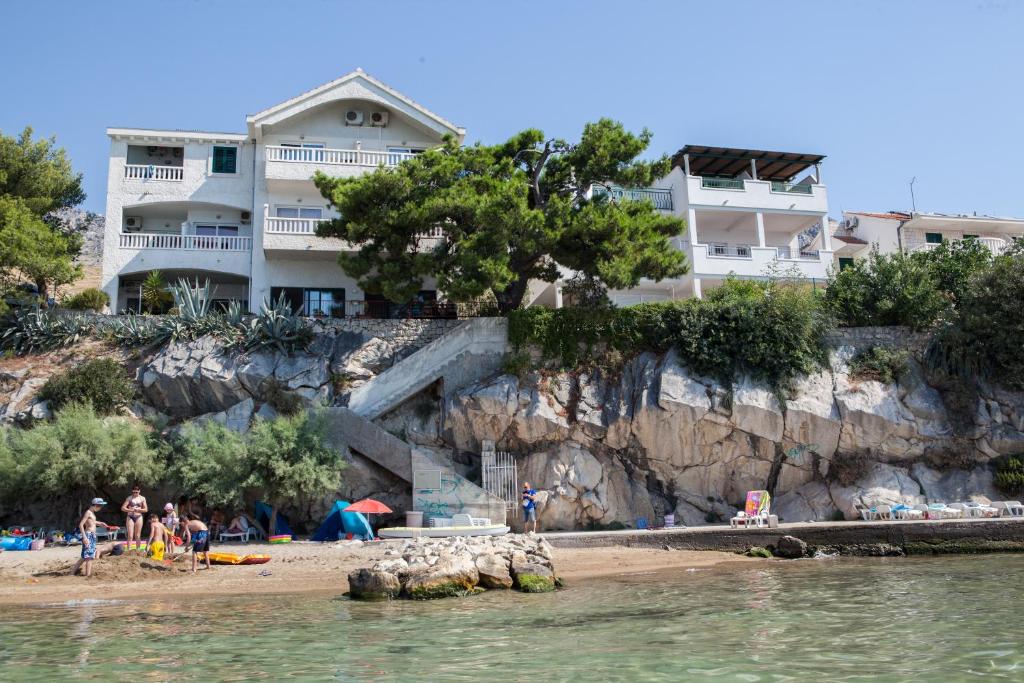 a house on a cliff next to a beach at Apartments Agava-Mirjana in Omiš