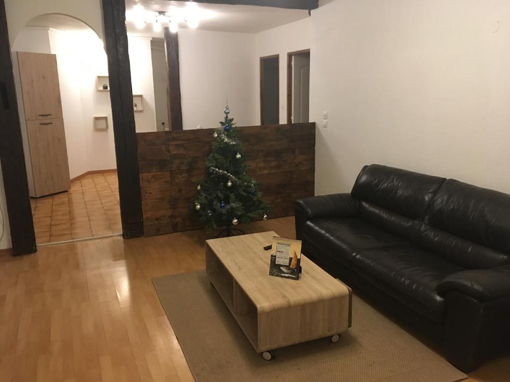 a living room with a christmas tree and a leather couch at Le Château du Fleckenstein in Sélestat