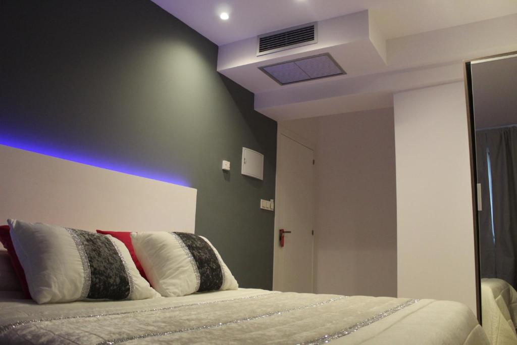 Un dormitorio con una cama con una pared de acento azul en Bilbao Place, en Bilbao