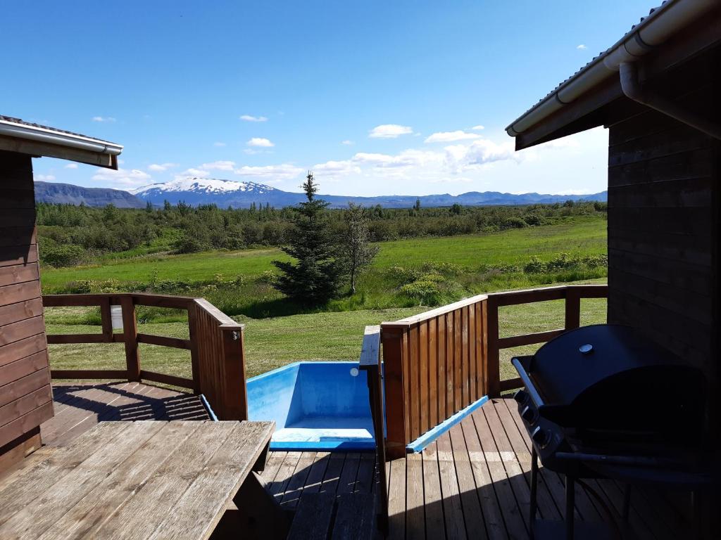 a deck with a pool and a table and a chair at Ásólfsstaðir Miðtún in Ásólfsstaðir