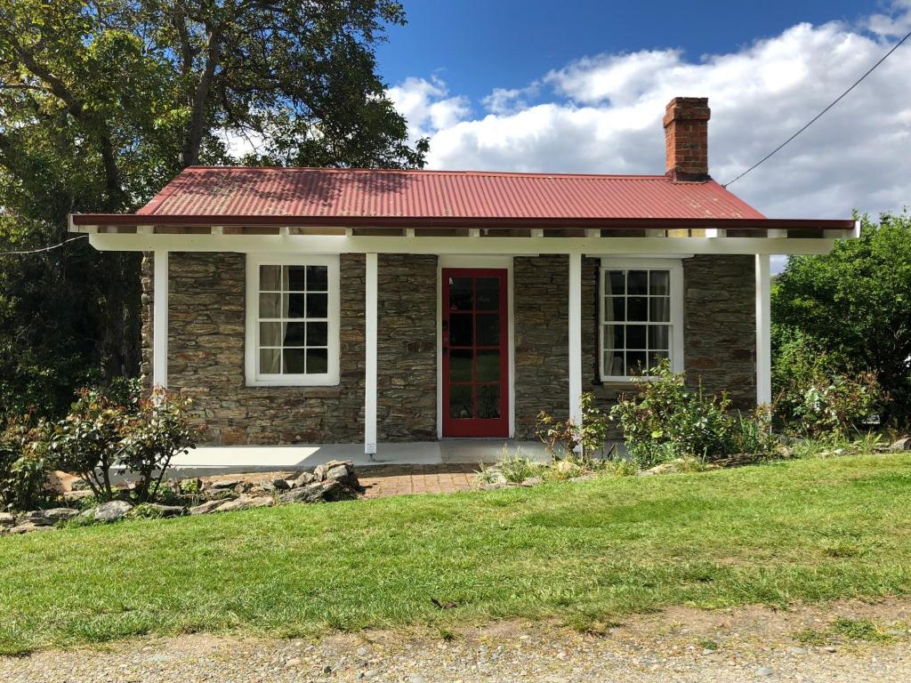 a small brick house with a red door at Dalton's Deed in Roxburgh