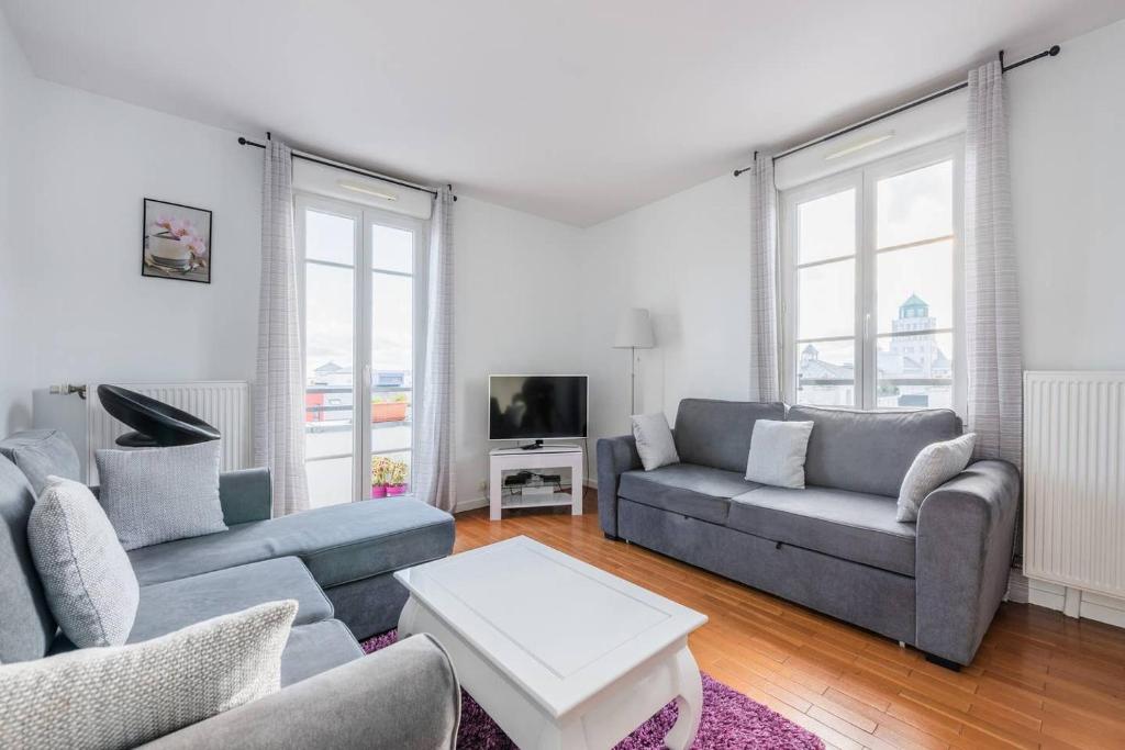 sala de estar con 2 sofás y TV en Smart apartment Val d'Europe 7/9 pers, en Chessy