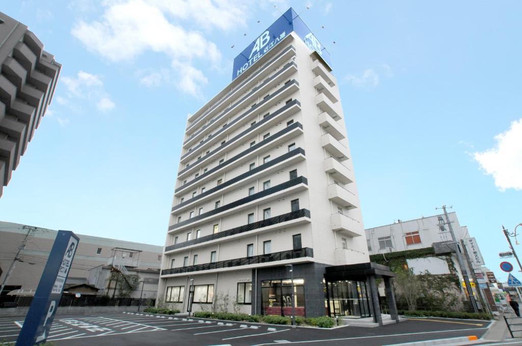 近江八幡的住宿－AB Hotel Omihachiman，一座高大的白色建筑,上面有标志