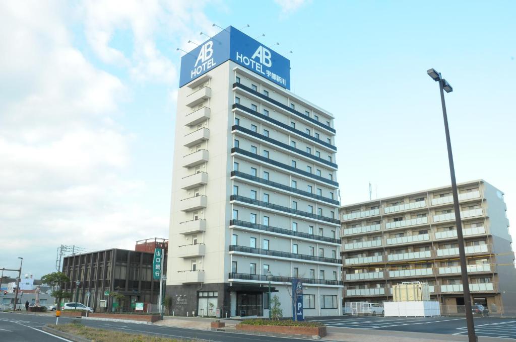 宇部的住宿－AB Hotel Ubeshinkawa，蓝色顶部的高大的白色建筑