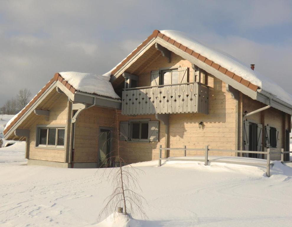 Casa cubierta de nieve con balcón en Chalet Flocon, en Plénise