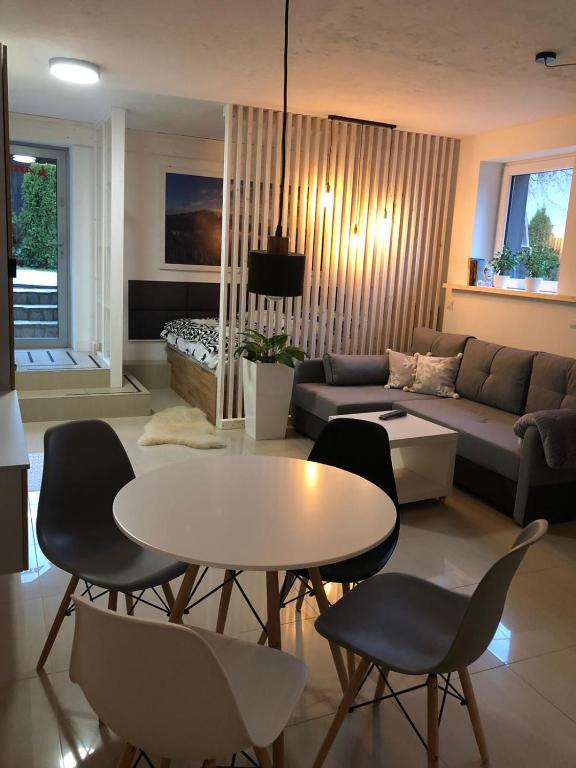 a living room with a couch and a table and chairs at Apartament BeSkidSki in Szczyrk