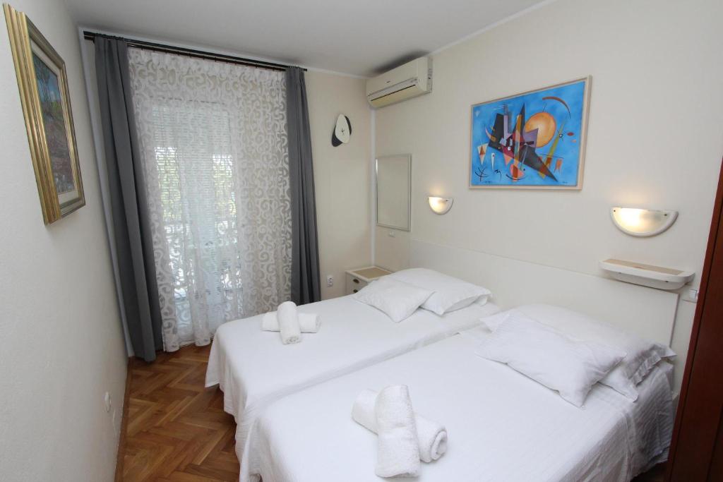 two white beds in a room with a window at Room Roma in Rovinj