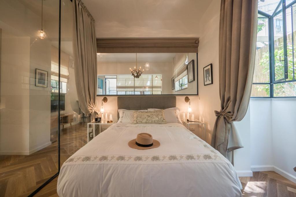 特拉維夫的住宿－VELLER Ben Yehuda，一间卧室,配有一张床,上面有帽子