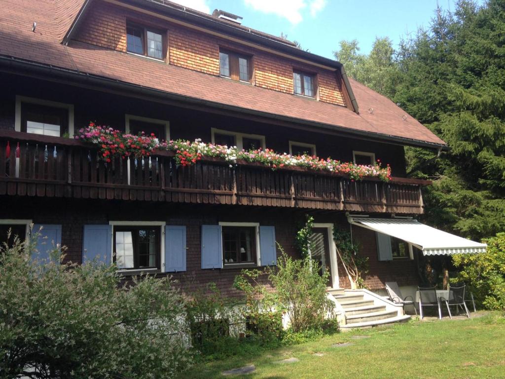 a large house with flowers on the balcony at Fuchs und Has' Gästehaus in Feldberg