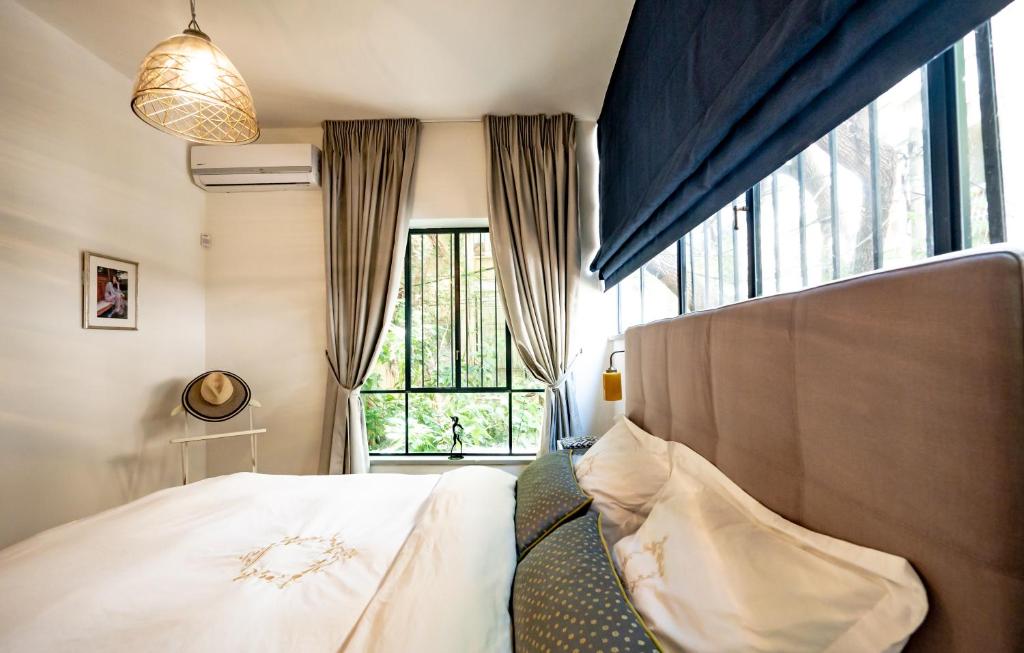 a bedroom with a bed and a large window at VELLER Olifant in Tel Aviv