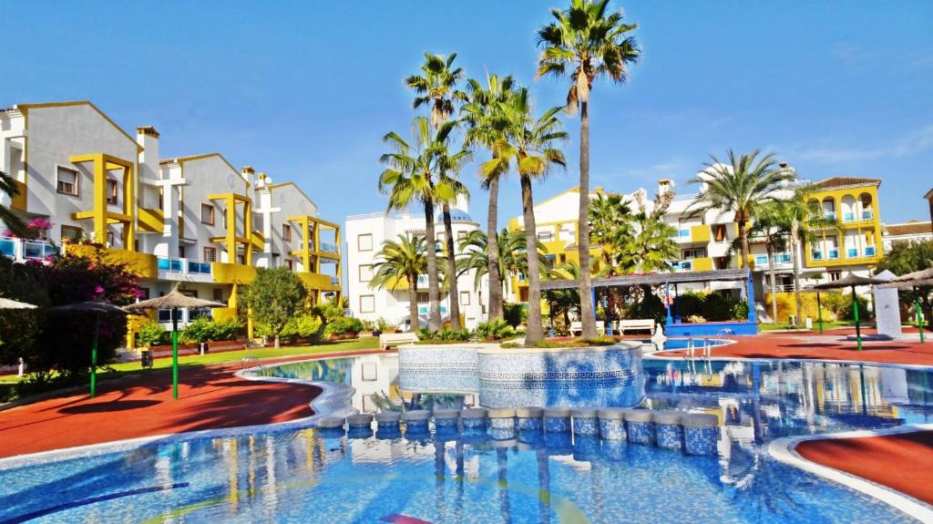 a pool at a resort with palm trees and buildings at PALMERAS EN LA PLAYA - Beach House in Oliva in Oliva