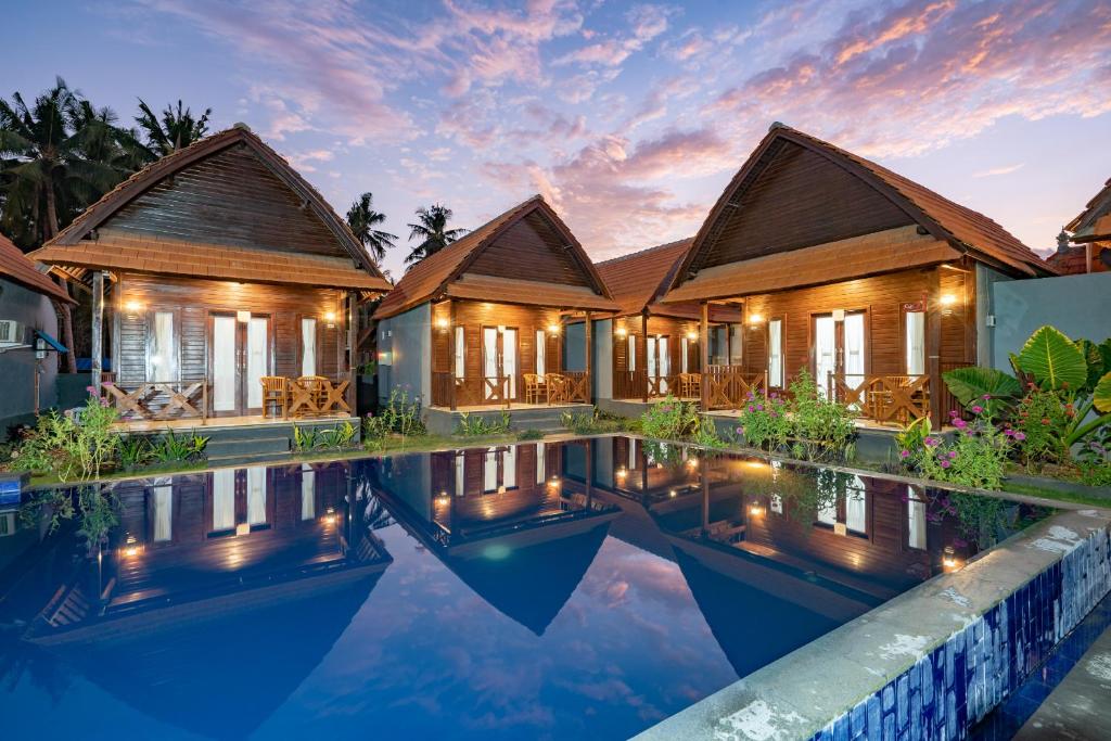 a villa with a swimming pool at dusk at Arjuna Bungalow in Nusa Penida