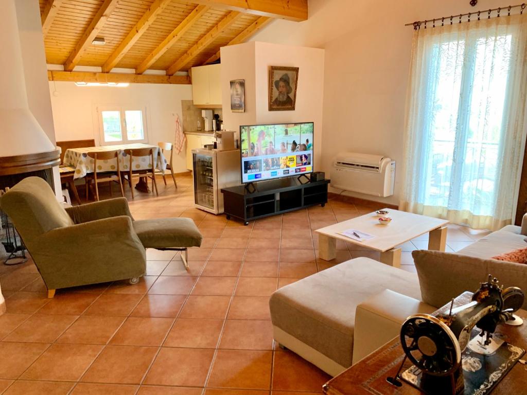 a living room with a couch and a tv at Comano Lugano Ticino - B&B Walterina in Comano