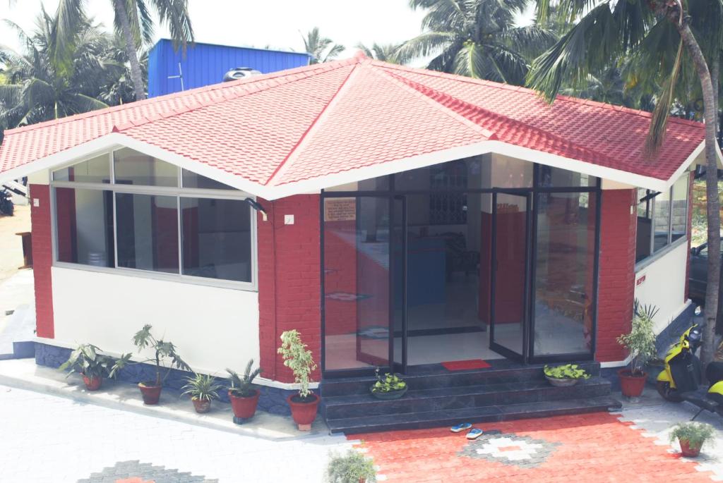 a red and white house with a red roof at Hotel Jebasakthy in Kanyakumari