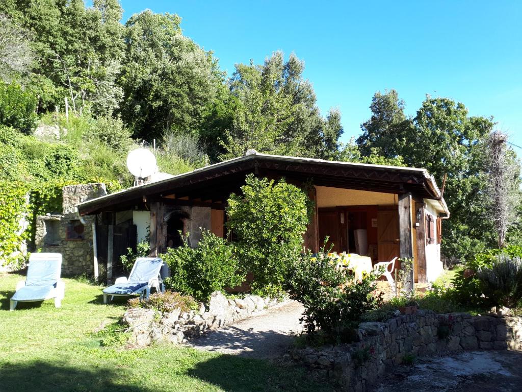 a house with two chairs in the yard at DISCRET, APAISANT, CALME entre MER et MONTAGNE in Isolaccio-di-Fiumorbo