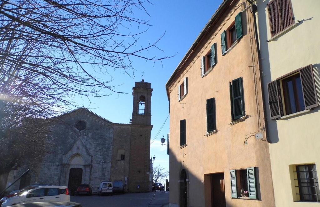 eine Kirche mit einem Uhrturm und einem Gebäude in der Unterkunft CASA SERENA UNO - CENTRO STORICO in Montepulciano