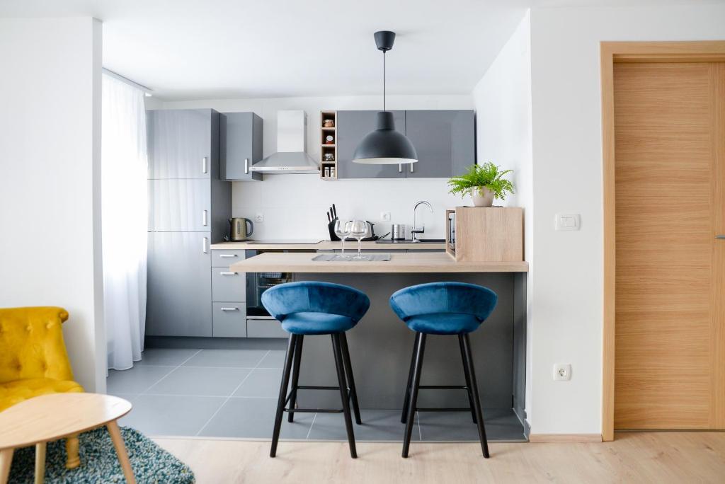 a kitchen with blue stools at a kitchen counter at Dreamy Garden Zagreb in Zagreb