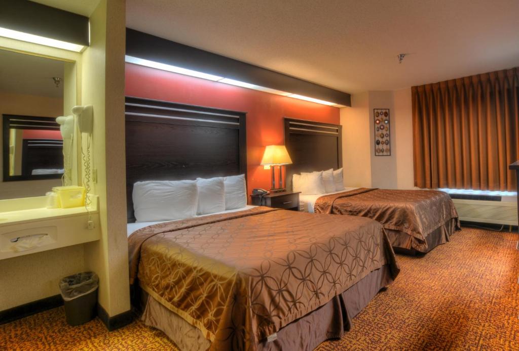 a hotel room with two beds and a window at Smoky Mountain Inn & Suites in Cherokee
