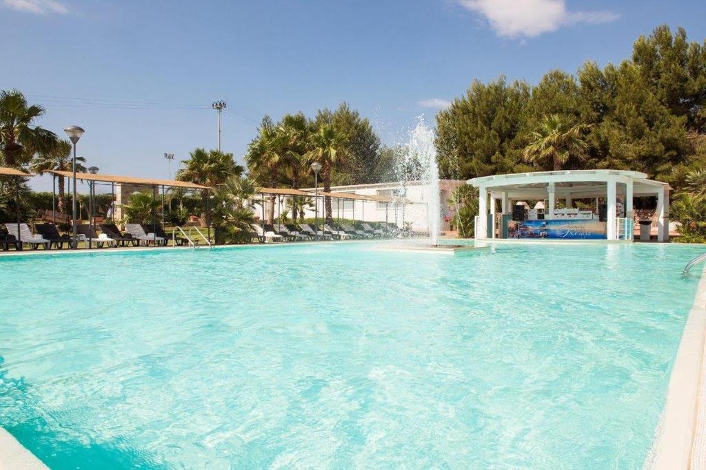 a large swimming pool with a water fountain at Masseria Grottella in Avetrana