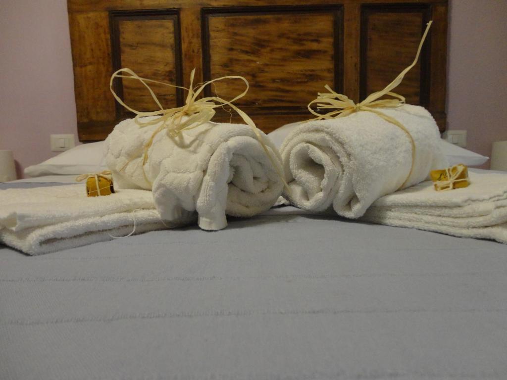 Il Glicine في سان جيمنيانو: يجلس اثنين من حيوانات المنشفة على رأس سرير