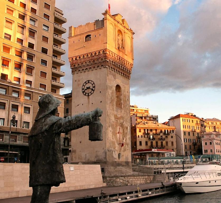 una torre dell'orologio con una statua davanti di Costa e Mare a Savona