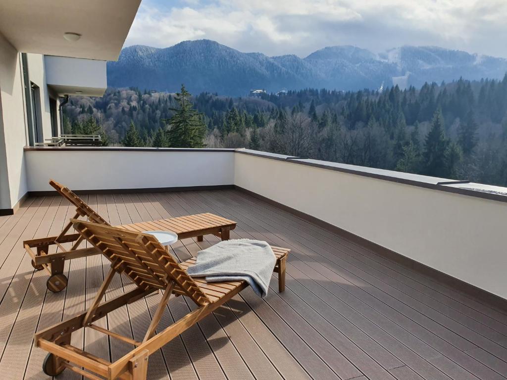 een terras met 2 stoelen en een tafel op een balkon bij Silver Fox Residence in Poiana Brasov
