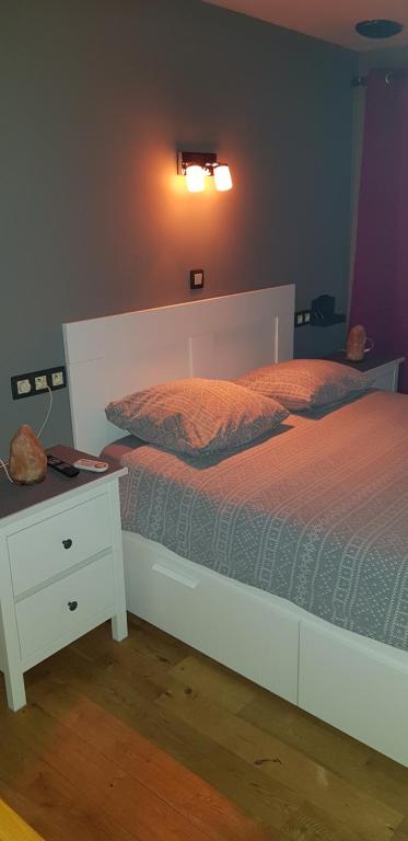 una camera con letto bianco e comodino bianco di Location court terme a Namur