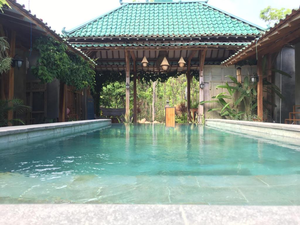 a swimming pool in a house with a gazebo at Watukarung Ristu Homestay in Kalak