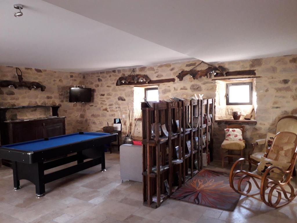 Habitación con mesa de ping pong y algunas sillas. en Chambre d'hôtes Le Cascadou, en Banassac