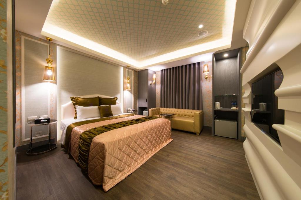 um quarto de hotel com uma cama grande e uma casa de banho em Discovery Motel - Yonghe em Yonghe