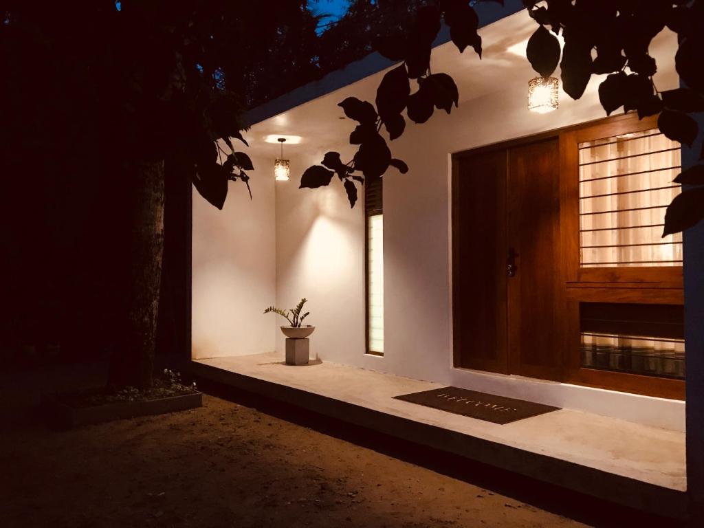 een huis verlicht in de nacht met een raam en een potplant bij The Loft in Midigama East