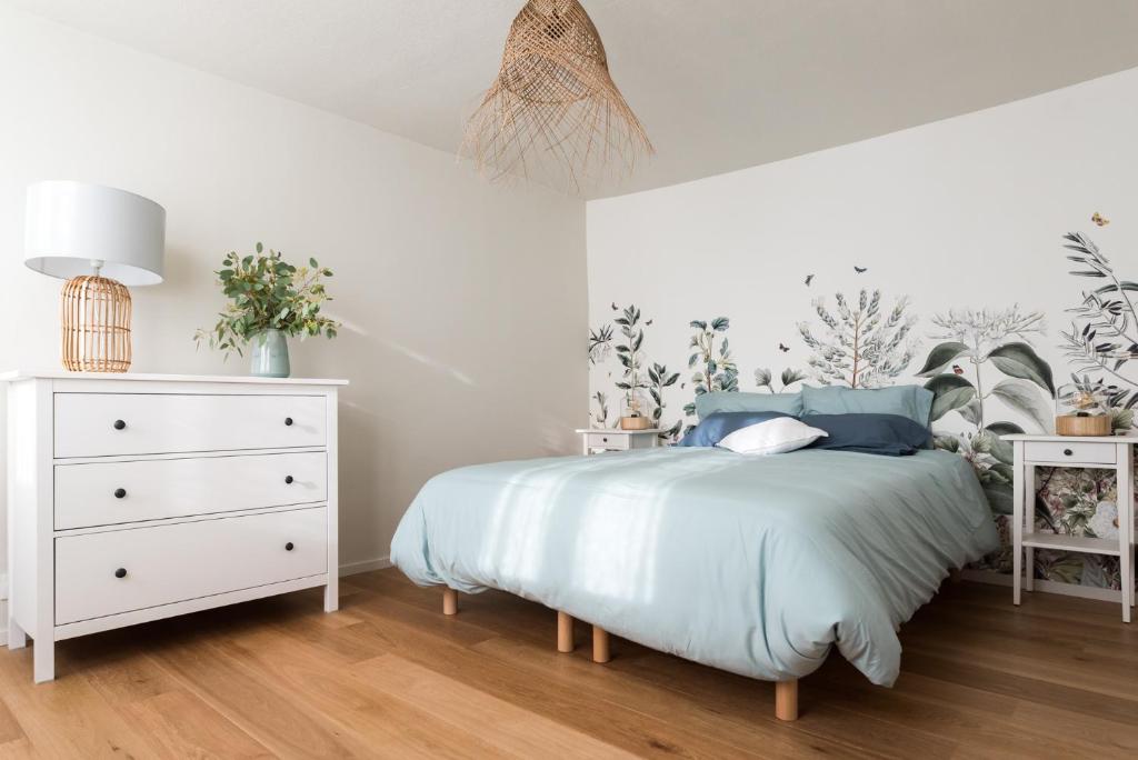 een slaapkamer met een bed en een witte dressoir bij Le cocon de Jules in Colmar