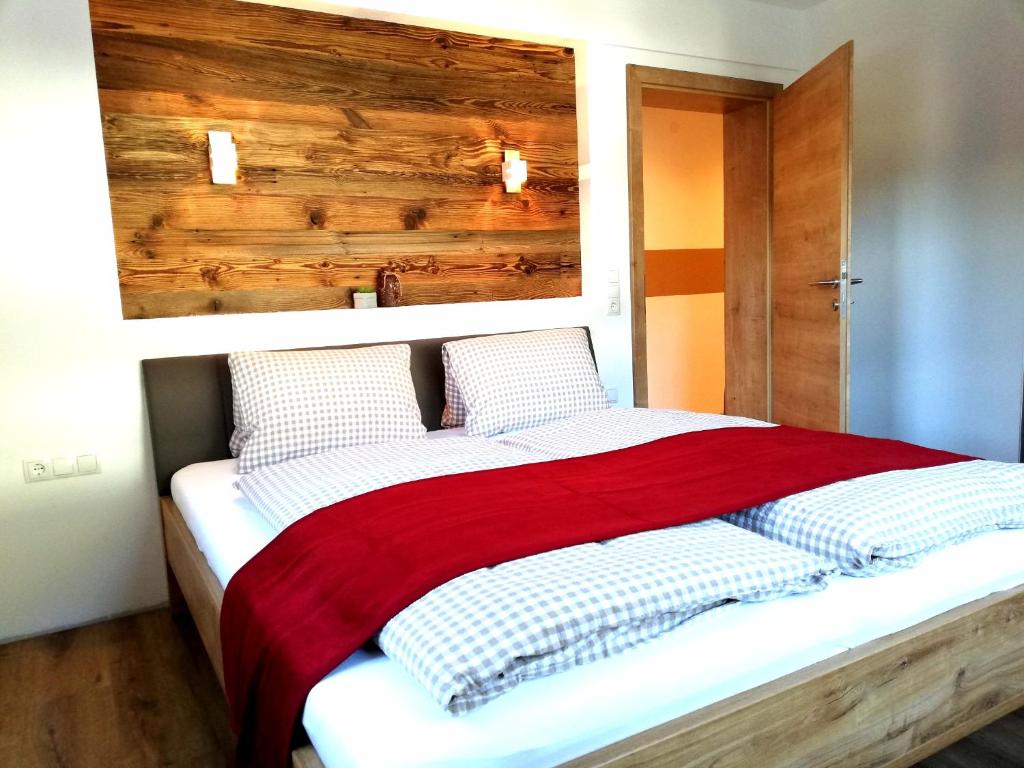 a bedroom with a large bed with a red blanket at db Apart in Finkenberg