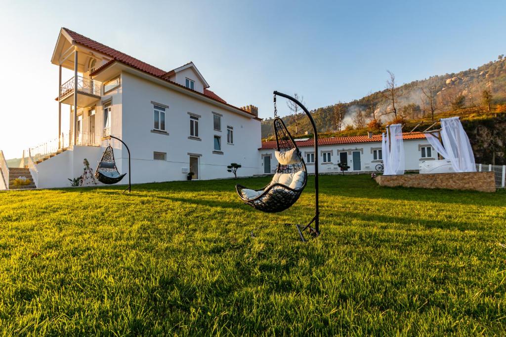 two swings in a yard in front of a house at Villa Alzira in Seia