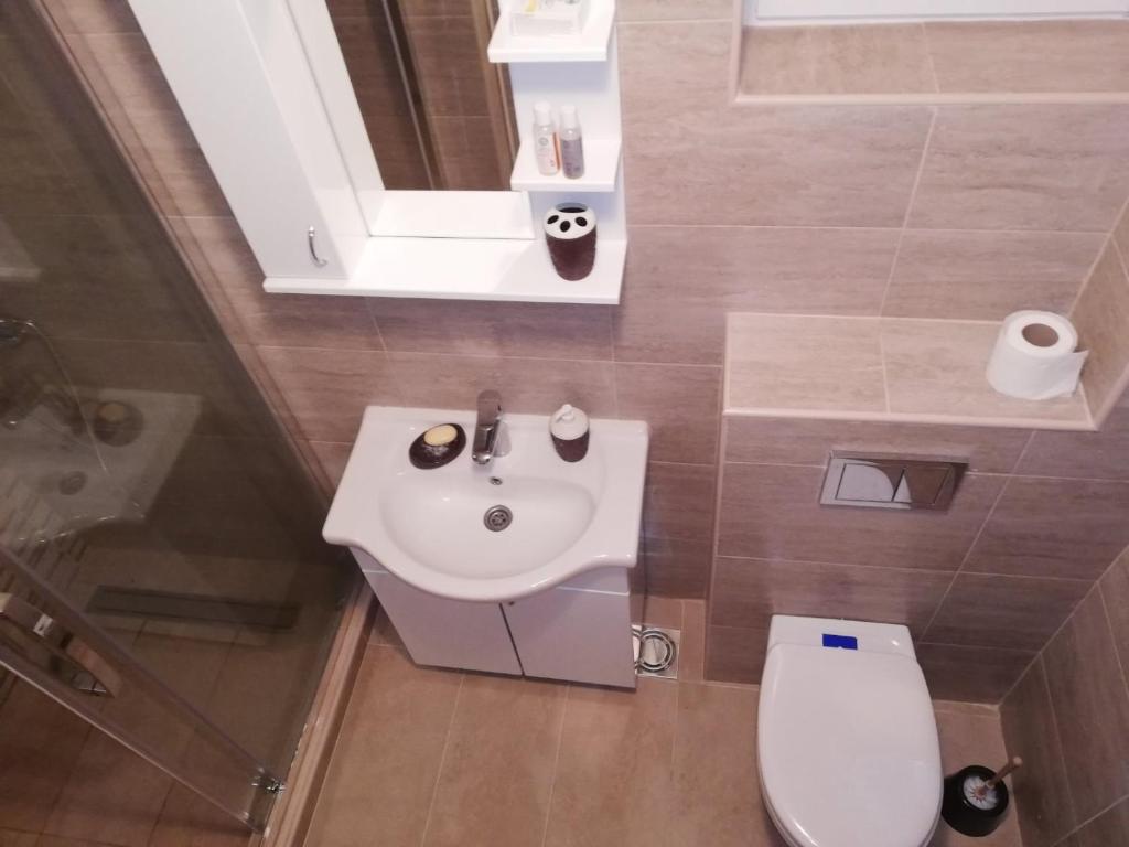 a bathroom with a white sink and a toilet at Iznad oblaka A1 in Kopaonik