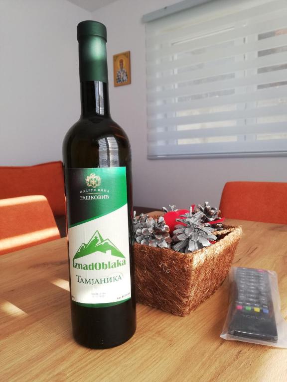a bottle of wine sitting on a table next to a basket at Iznad oblaka A1 in Kopaonik