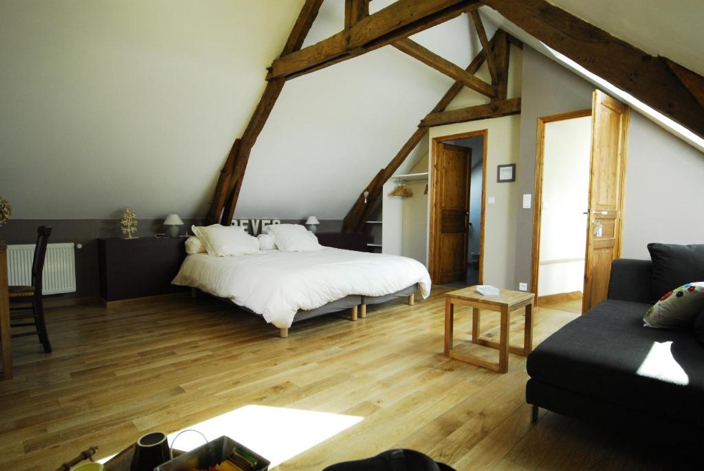 duży pokój z łóżkiem i kanapą w obiekcie Chambres d'hôtes La Penhatière w mieście Baulon